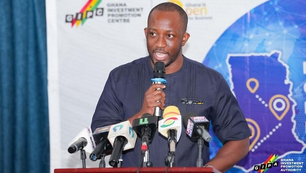 Man speaking at a podium with multiple microphones during a press conference or media briefing.