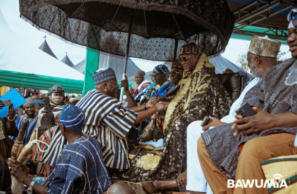 IMG-20260802-WA0014 | Ghanaguardian.com Senior Ghanaian dignitaries in ornate traditional robes shake hands beneath a large patterned umbrella at a public ceremony, surrounded by supporters and photographers.
