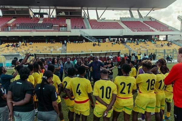 IMG_1452 | Ghanaguardian.com Yellow-clad women's soccer team forms a huddle on the field around a coach during a break in a stadium match.