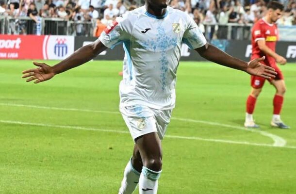 IMG_1510 | Ghanaguardian.com Soccer player in a white kit with arms spread, celebrating on the green field with a crowded stadium behind him.