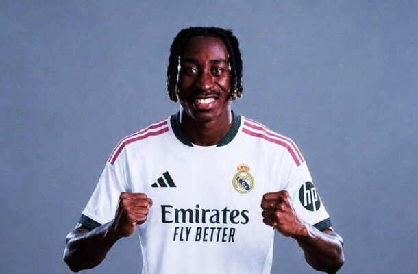 IMG_1576 | Ghanaguardian.com Soccer player in a Real Madrid jersey, smiling with fists raised in a celebratory pose against a plain blue-gray background.