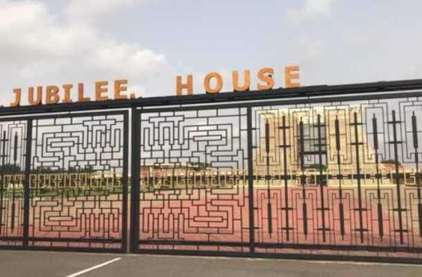 Decorative gate with geometric lattice design and orange 'JUBILEE HOUSE' lettering above it; a red track and open space behind the gate.