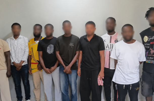 no_translation_7045_e0cy2fufqun7bgm01pwyz9lm_no_translation_translation | Ghanaguardian.com Ten men standing in a row against a gray wall, faces blurred for privacy.