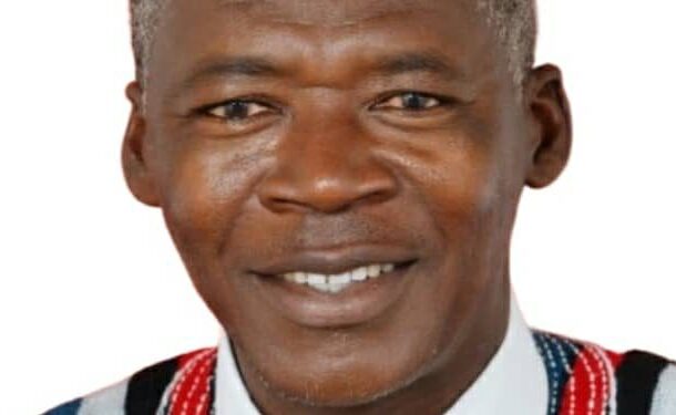 Portrait of a smiling Black man wearing a white shirt and colorful patterned vest against a white background to convey friendliness and cultural dress.