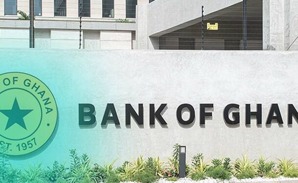 Exterior wall with the large 'BANK OF GHANA' sign and a green circular Bank of Ghana seal on the left, plus landscaped plants in front.